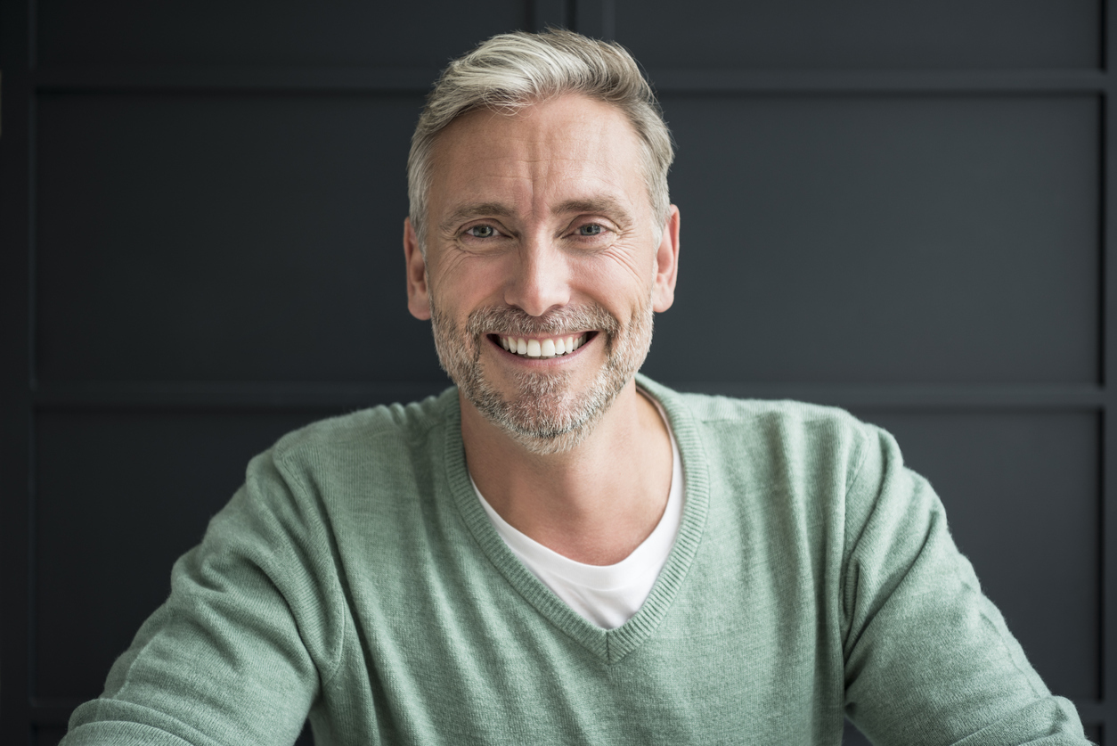 Portrait of mature man with relaxed carefree expression in v neck sweater