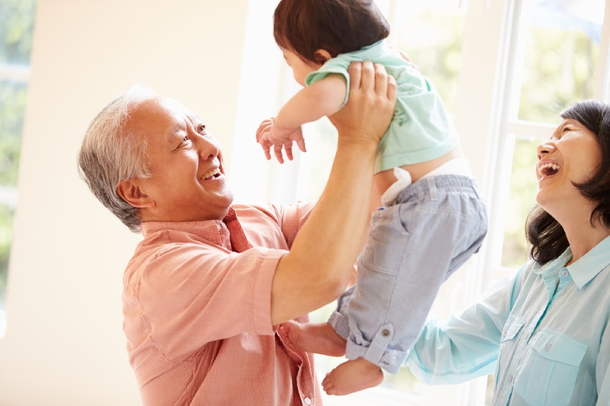 grandfather holding grandchild while grandmother looks on, things grandparents should never do