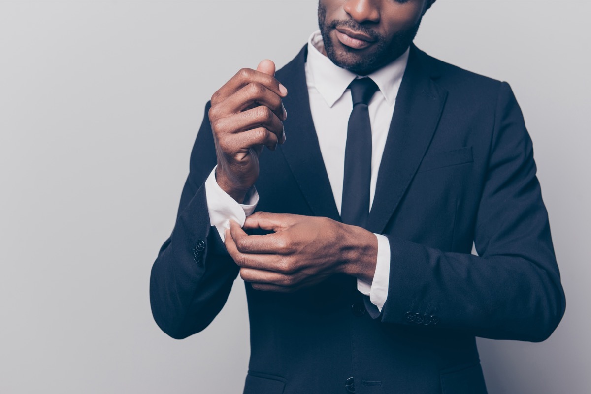 a man buttoning up his suit cuff 