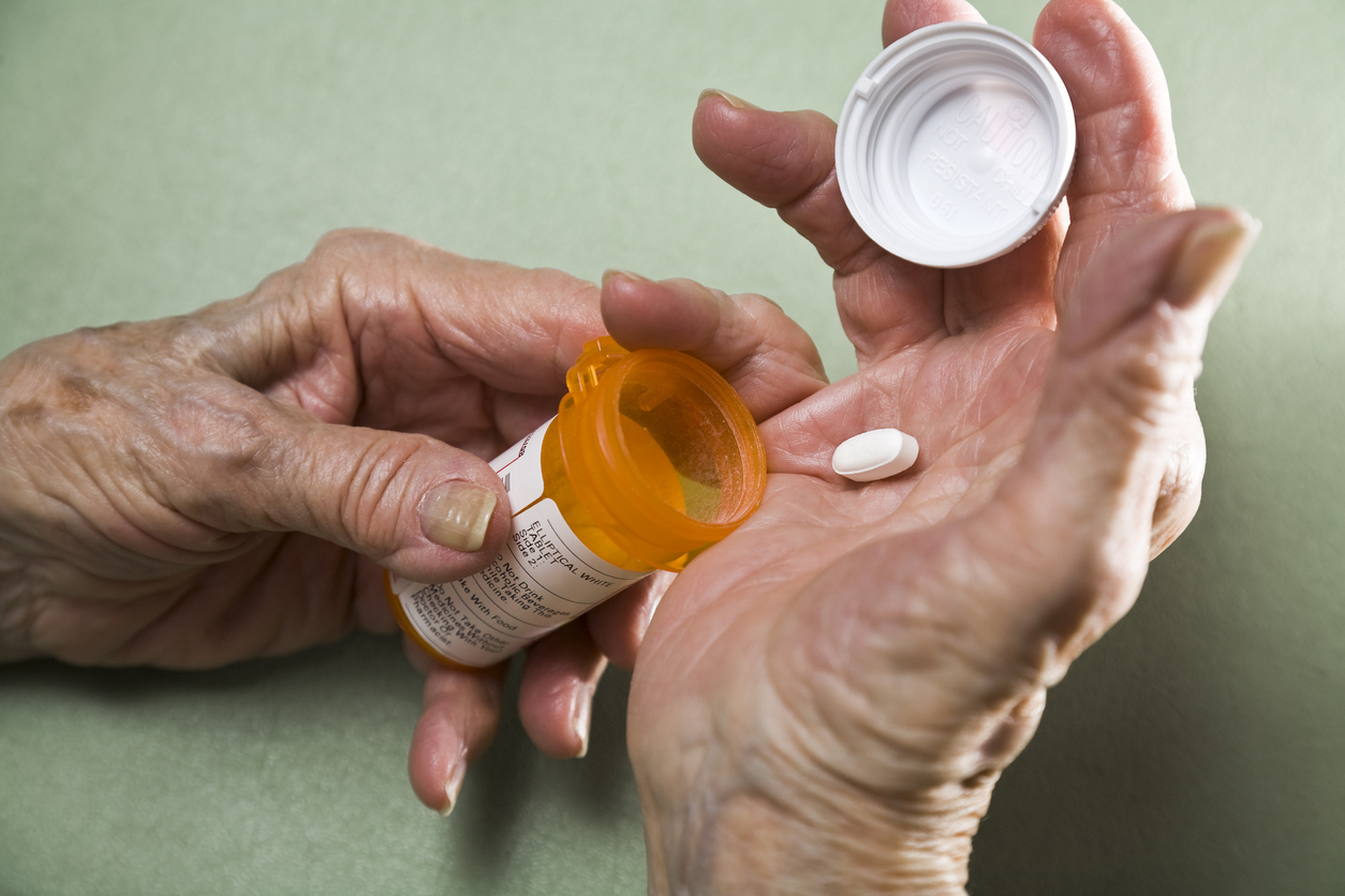 Woman holding prescription medicine bottle.