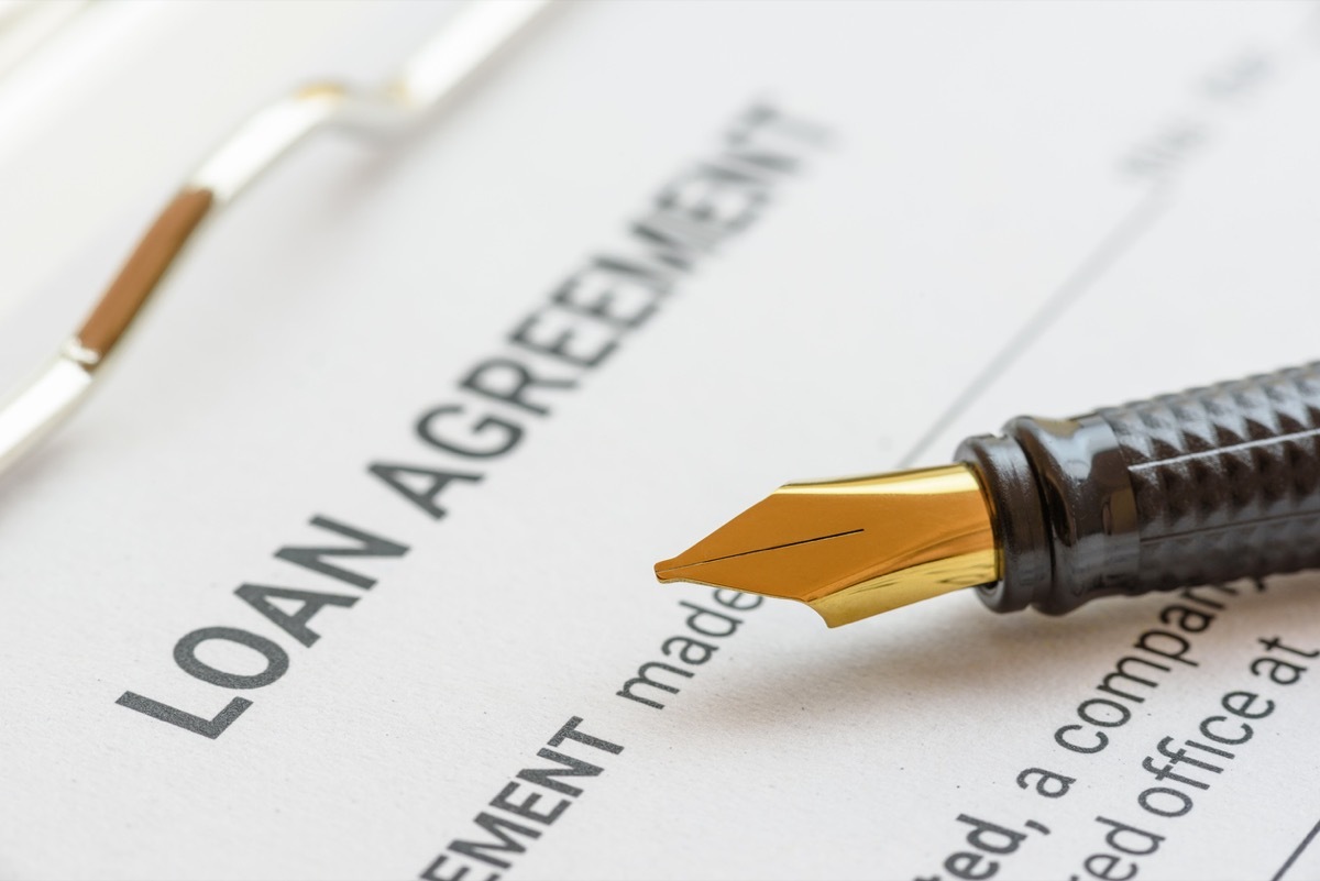 Business loan agreement or legal document concept : Fountain pen on a loan agreement paper form. Loan agreement is a contract between a borrower and a lender, a compilation of various mutual promises.