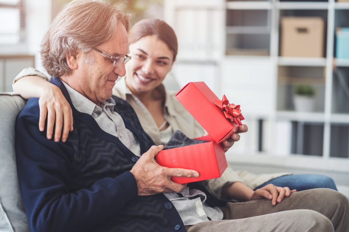 young girl giving father gift in red box