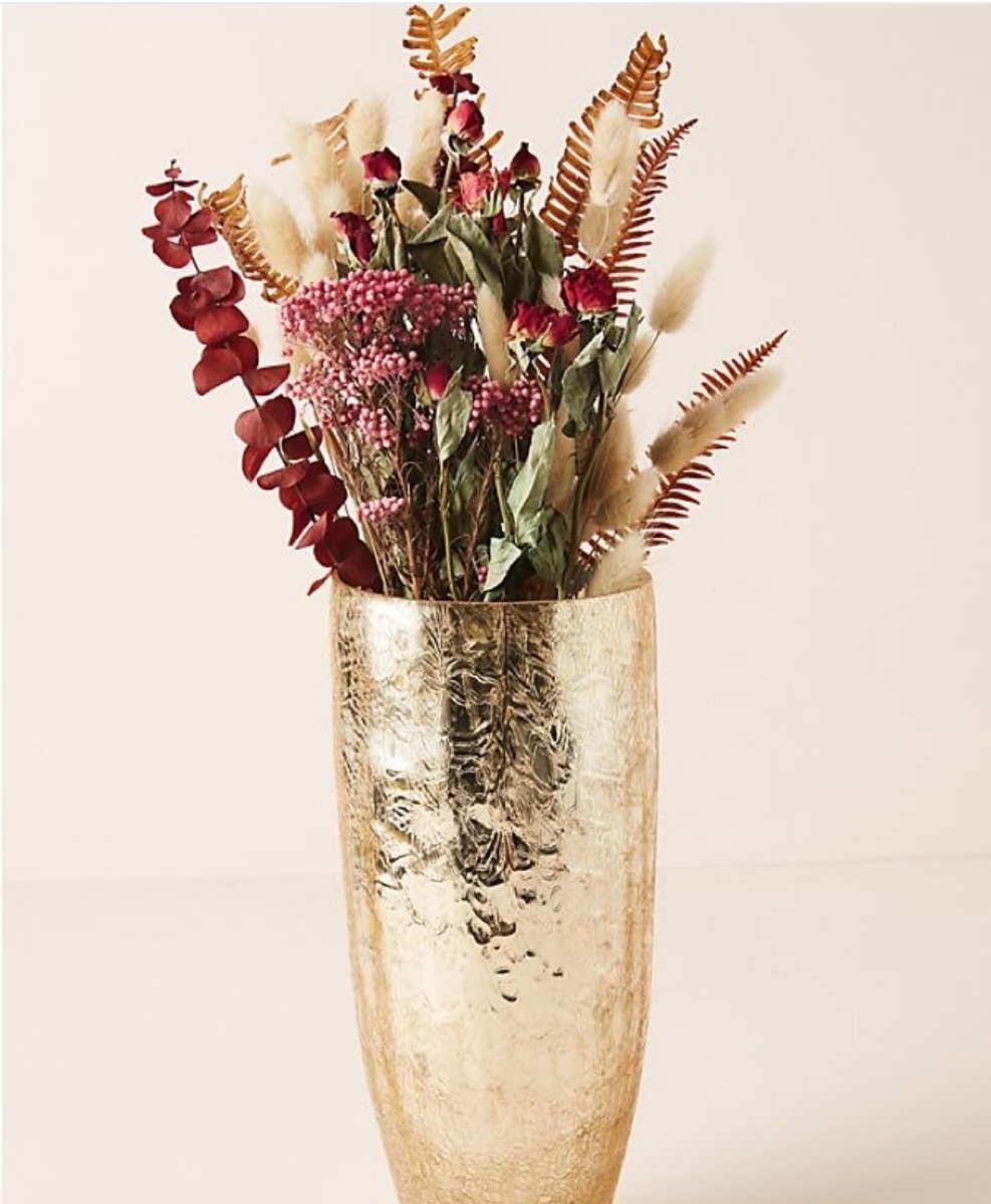 gold vase with wildflowers in it