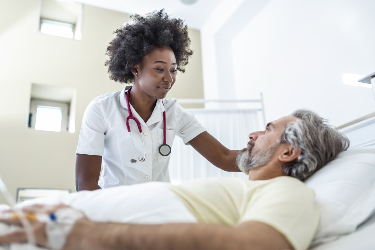 Doctor comforting elderly patient in hospital bed or counsel diagnosis health.