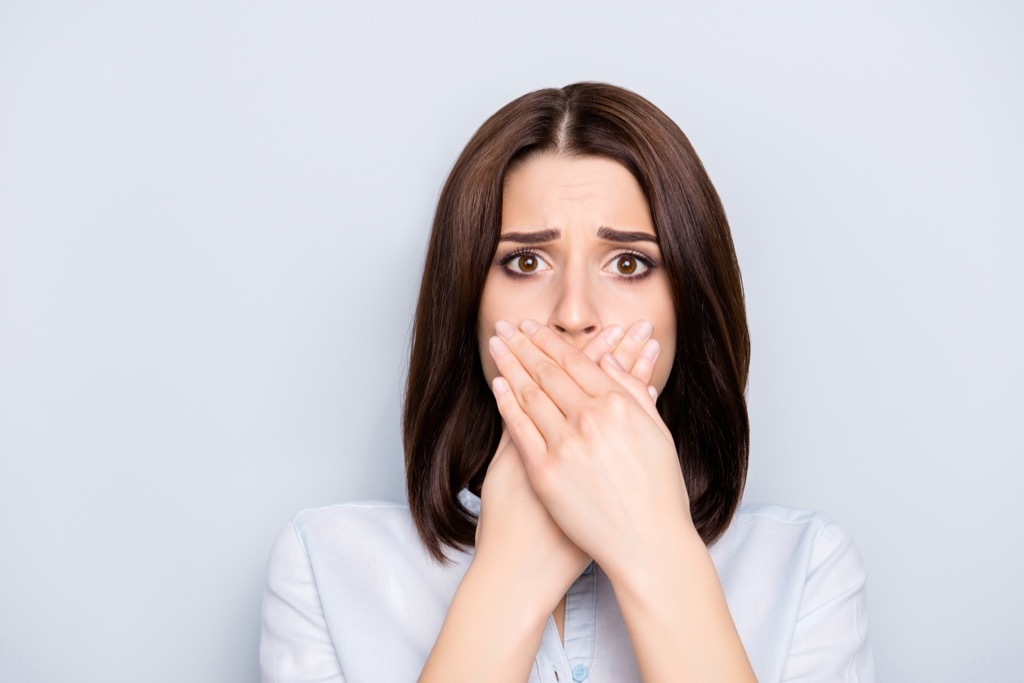 Woman with hands in front of her mouth