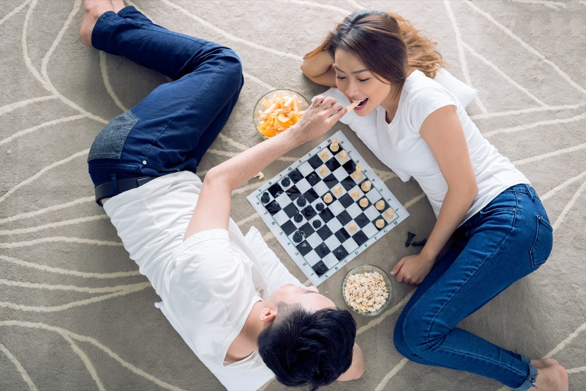 Couple having a board game date night playing chess