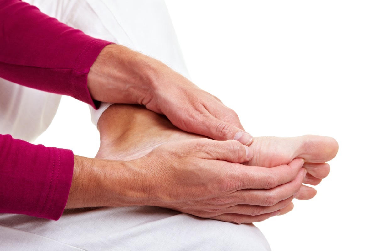 Senior man massaging his aching feet with his hands