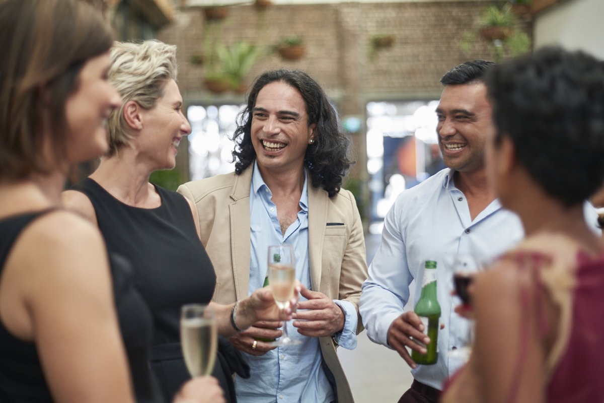 group of friends laughing in circle at party