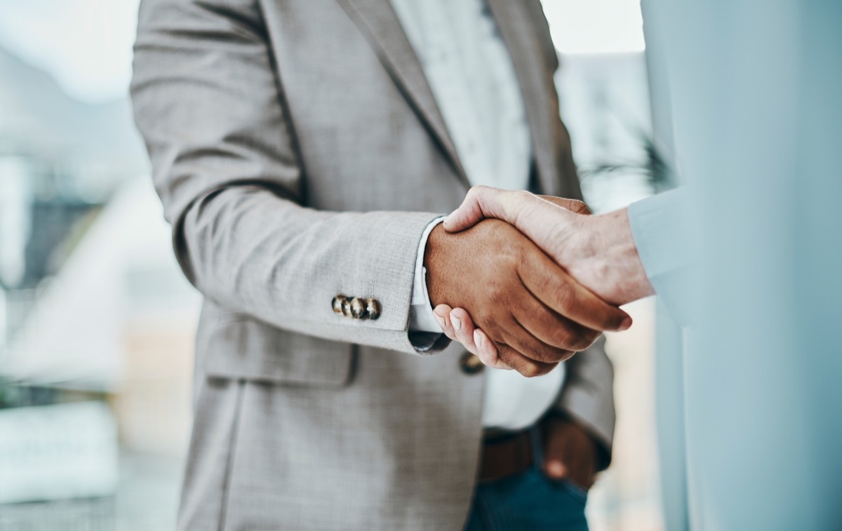 Shot of a businessman and businesswoman shaking hands in a modern office