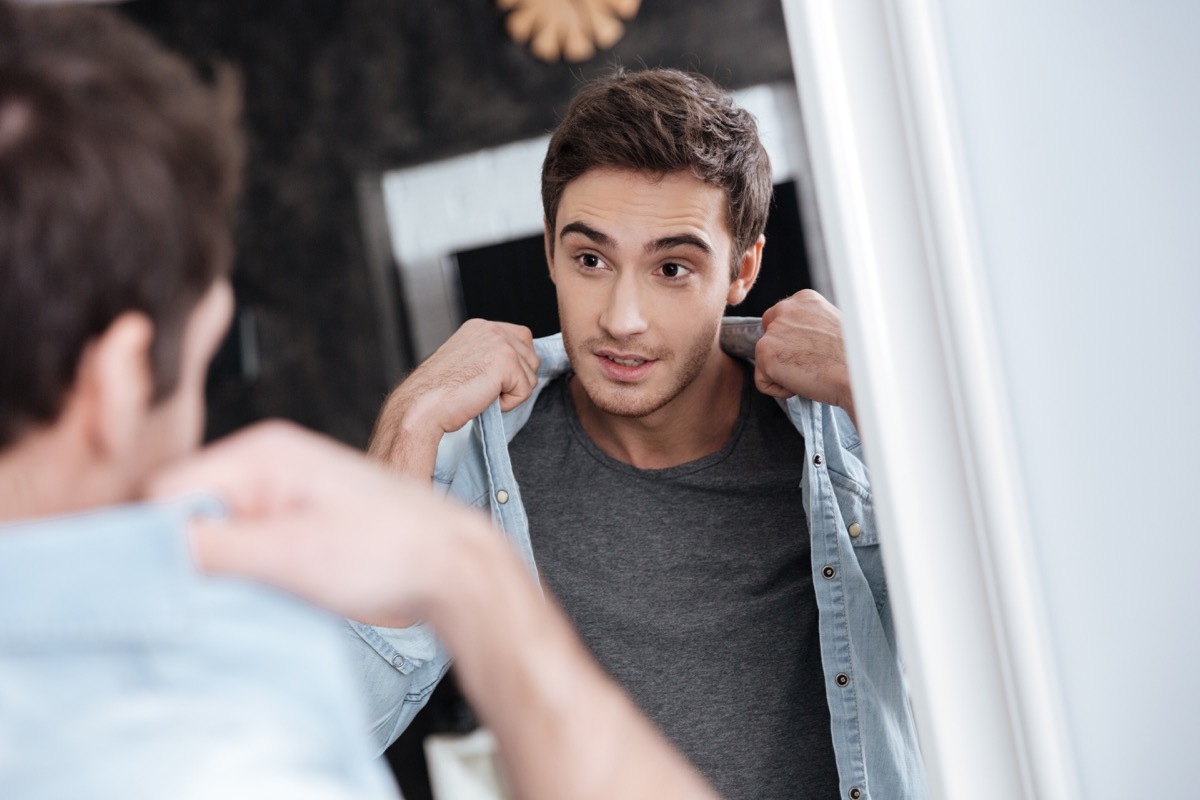 young white man looking at himself in the mirror