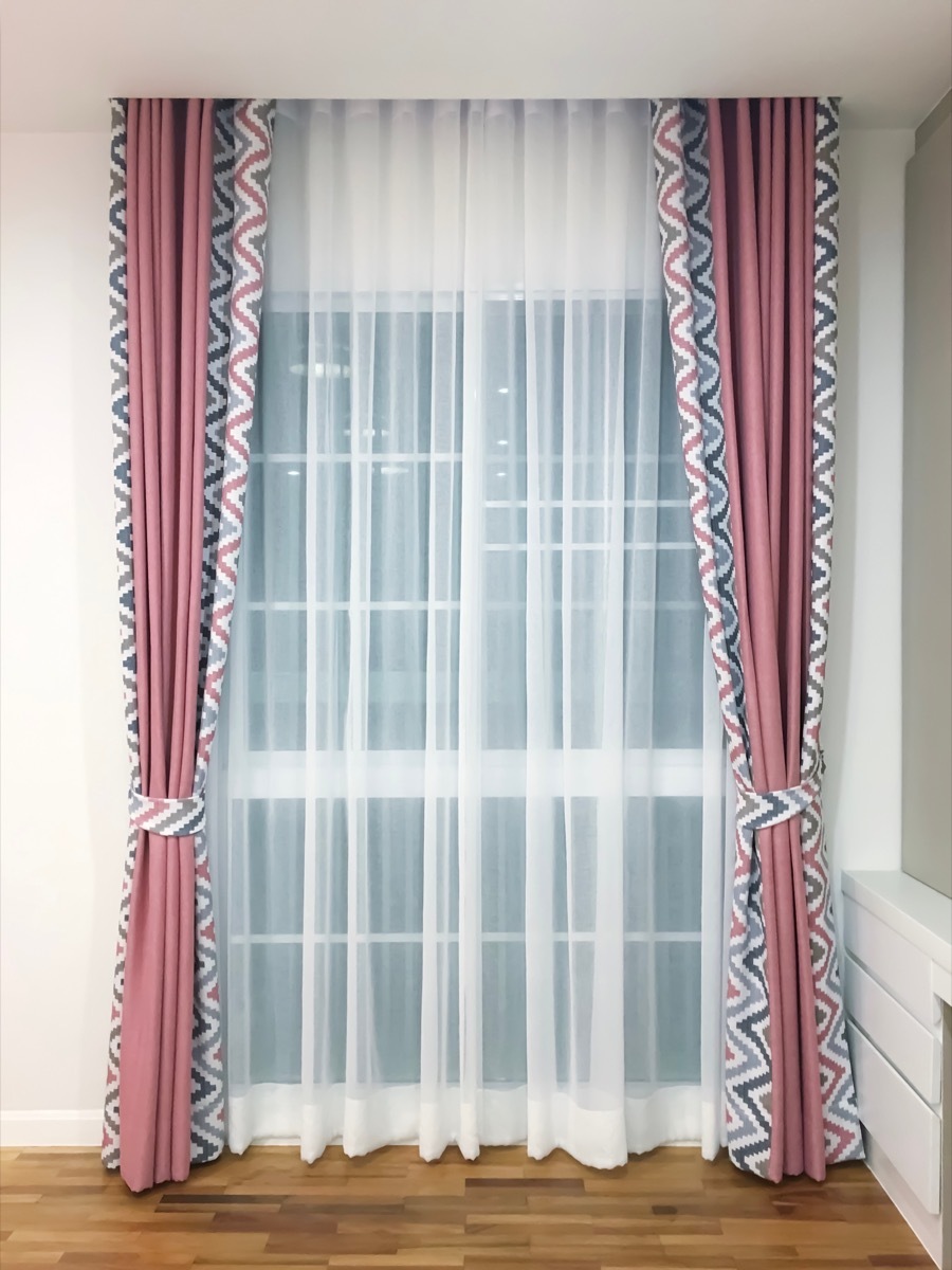 Pink and patterned blackout curtains on a window