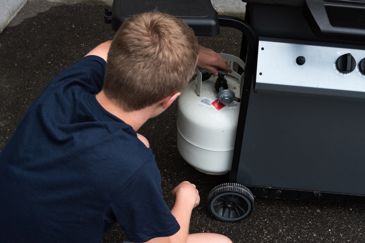 Man doing propane tank inspection on gas grill