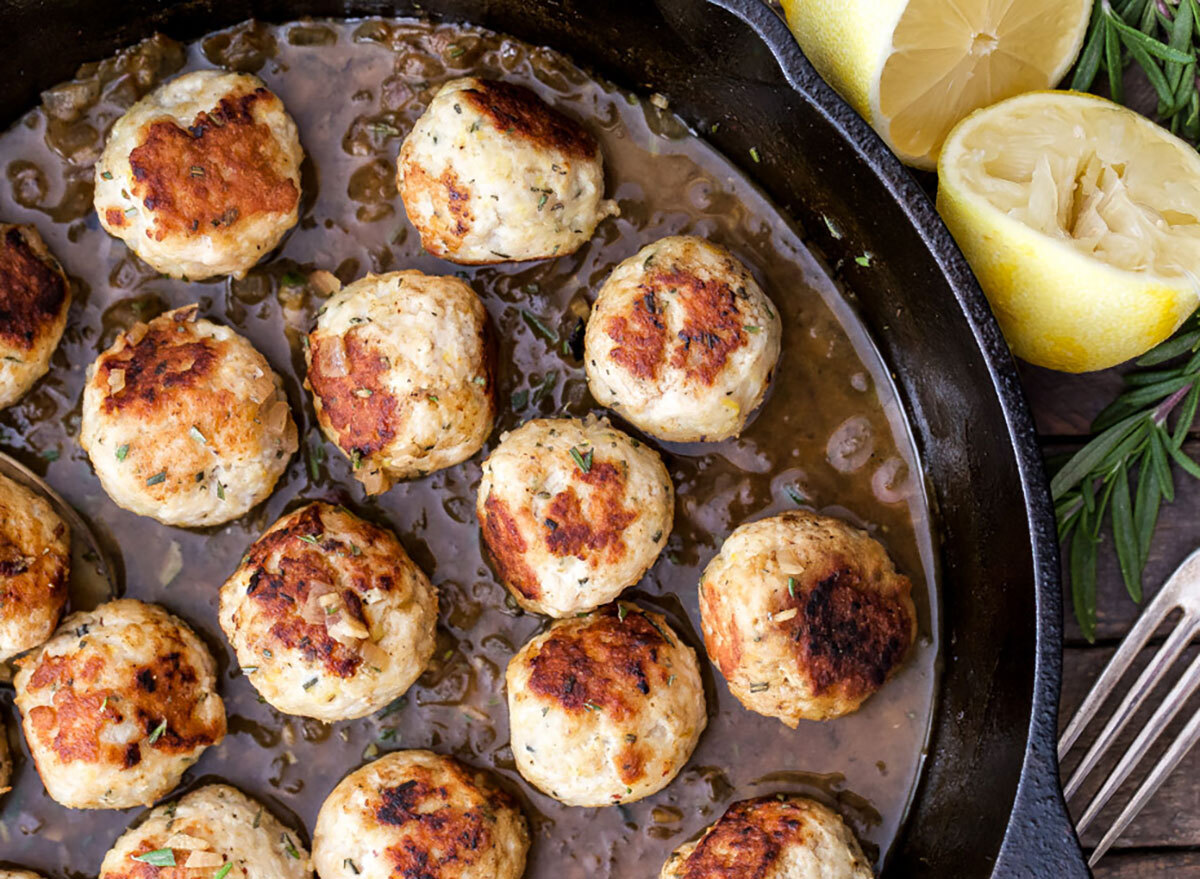 pan of lemon rosemary turkey meatballs with halved lemon