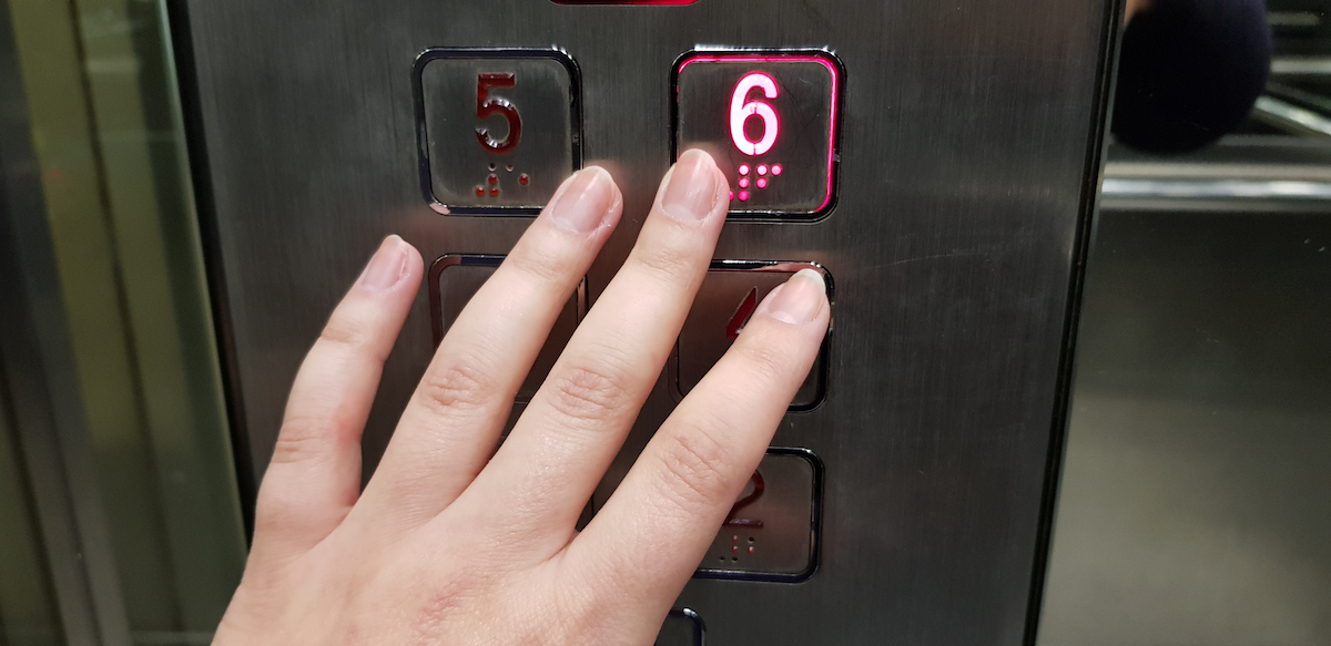 female hand pushing number six on metal control panel red light is on