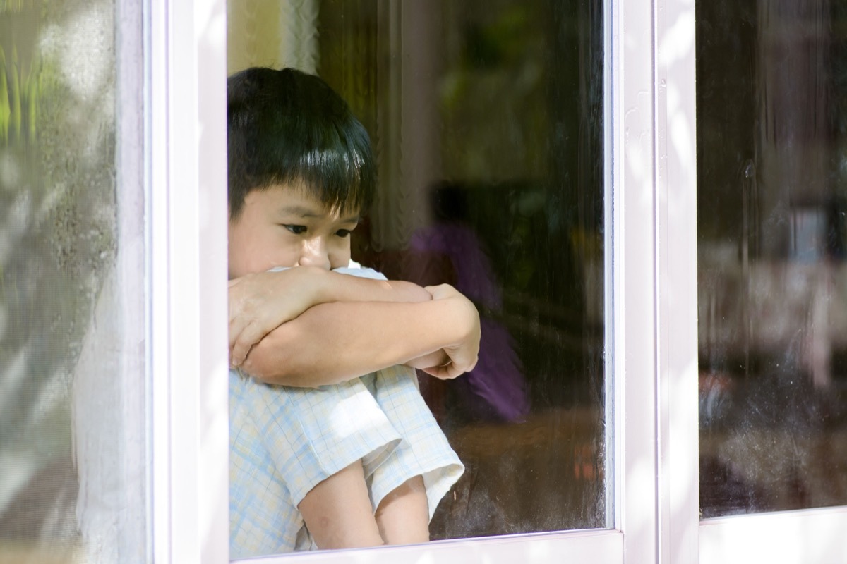 upset sad boy sitting by the window looking out of it, skills parents should teach kids