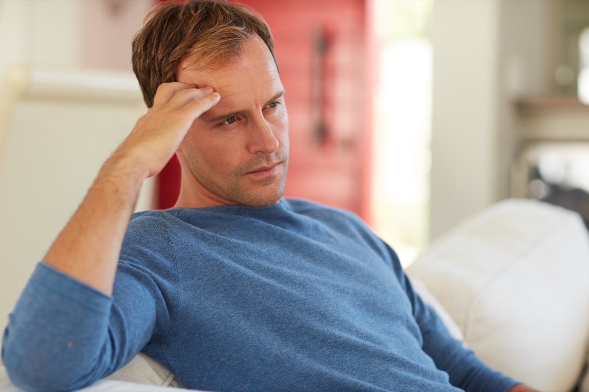 cropped shot of a mature man looking contemplative at home