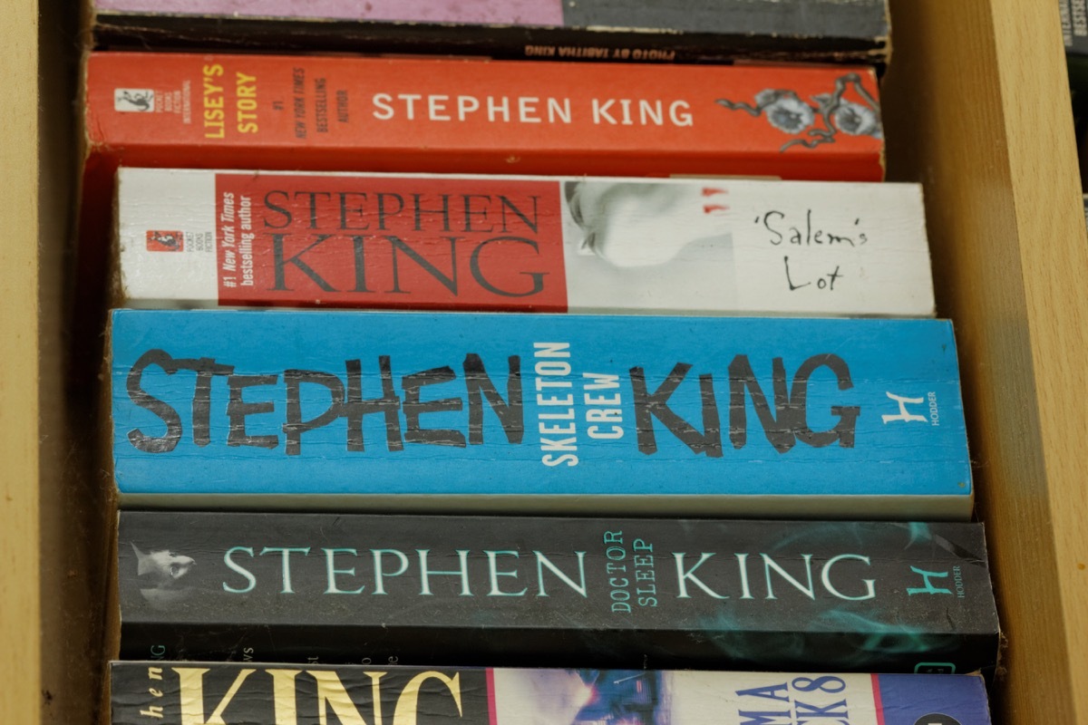 JOHOR,MALAYSIA - JULY 28, 2016: Assorted books written by famous thriller author Stephen King on display in wooden rack.