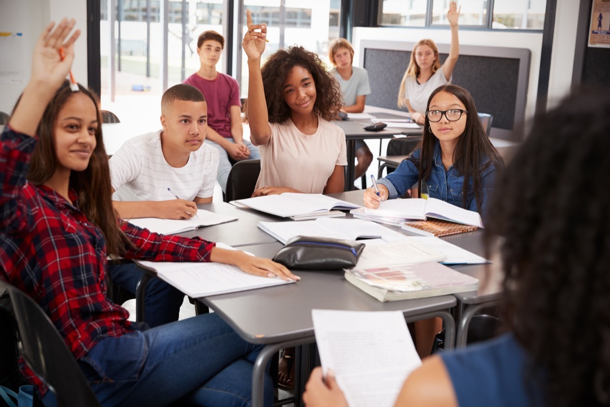 Older students raising their hand in class