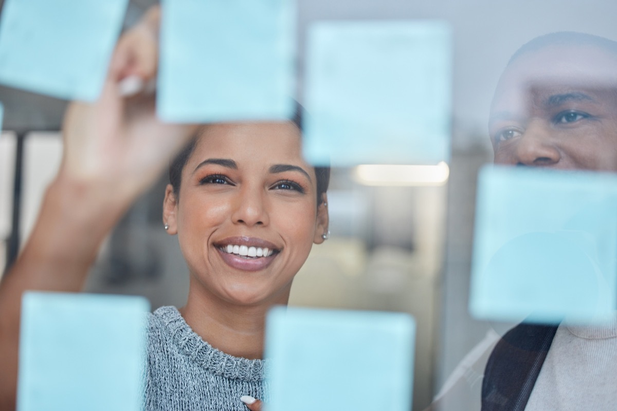 shot of two people creating a vision board together