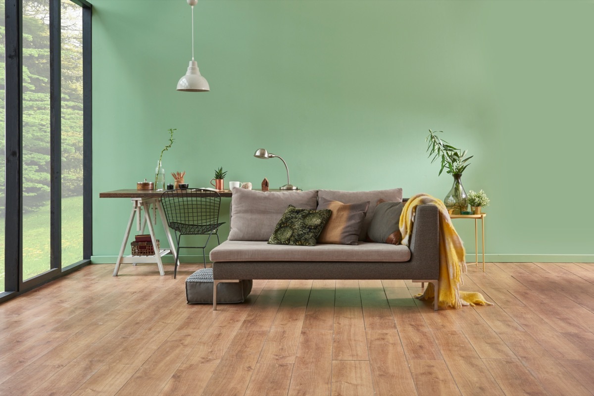 green room with gray couch and large windows