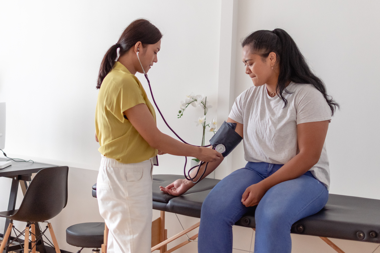 Woman having blood pressure taken in a doctor's office. 