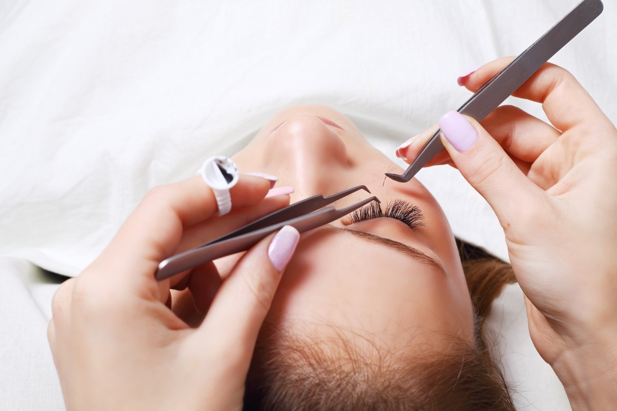 Woman getting false eyelashes put on