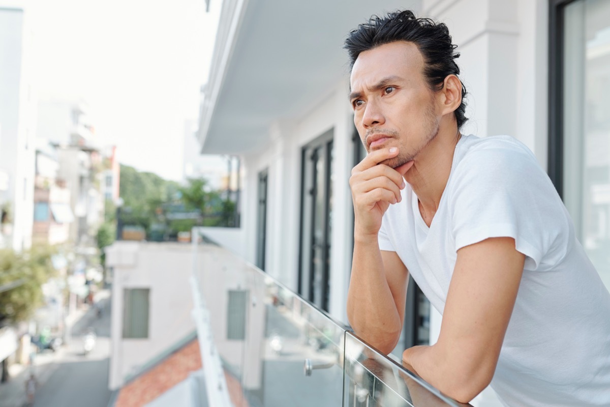 Vietnamese man rubbing his chin looking pensive