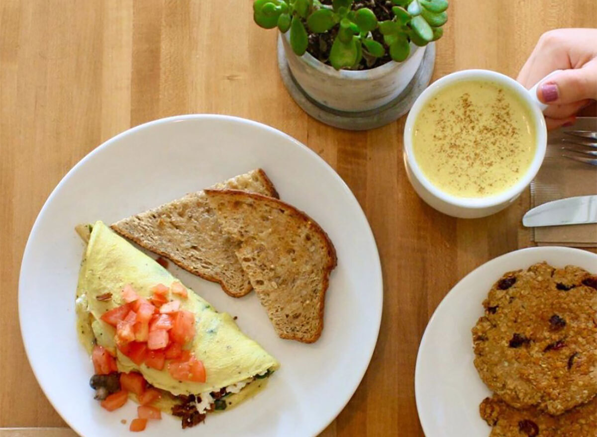 omelet topped with tomatoes and served with toast and coffee