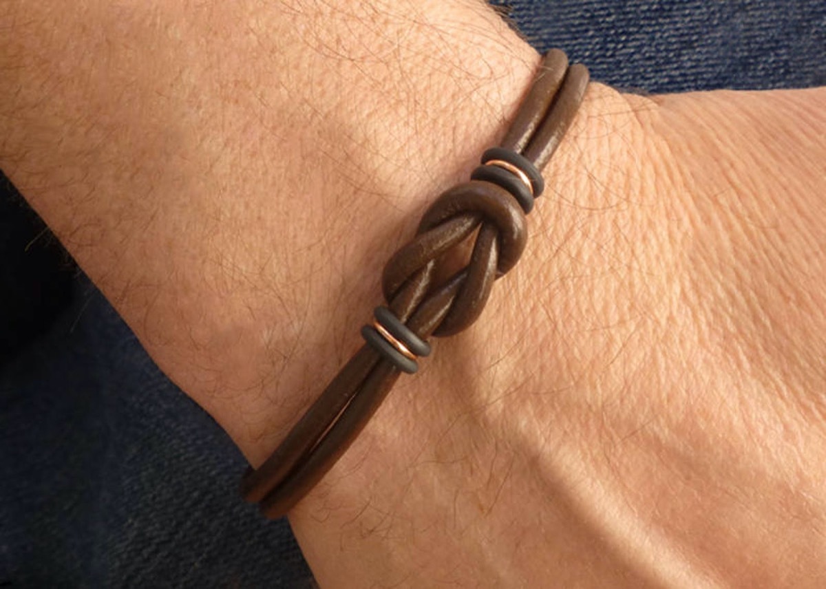 white man's wrist with brown leather bracelet