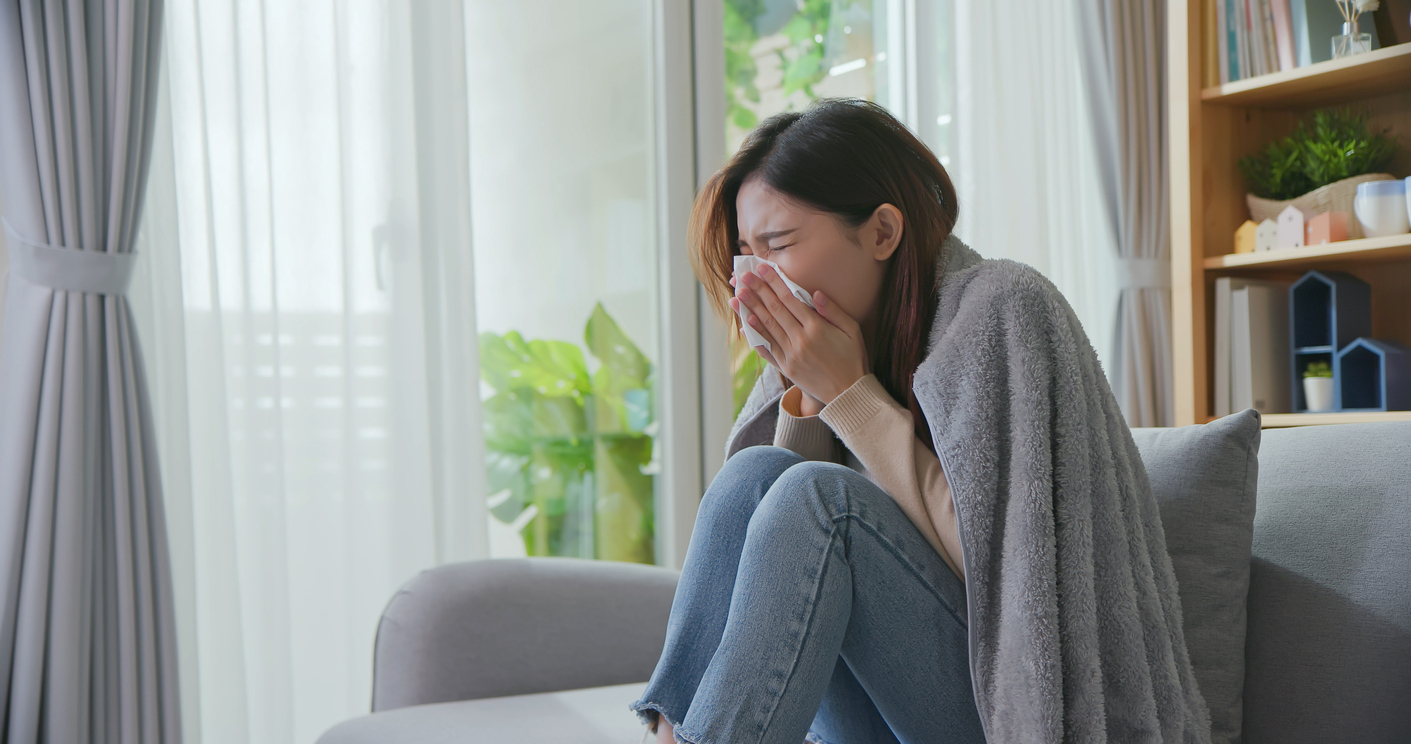 Woman coughing into a tissue