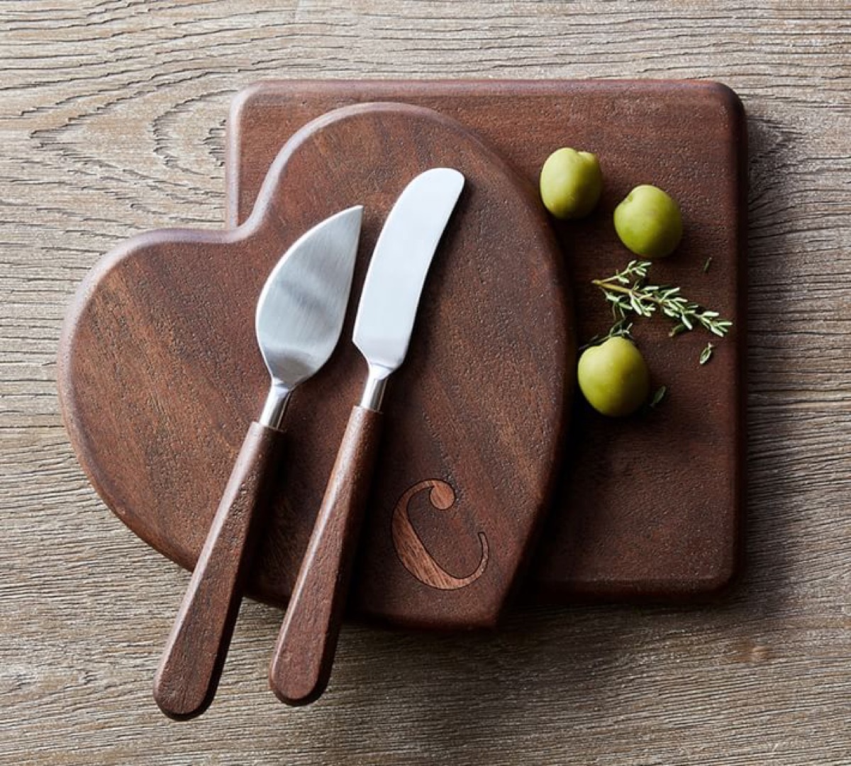 square and heart-shaped wooden cutting boards with cheese knives on top