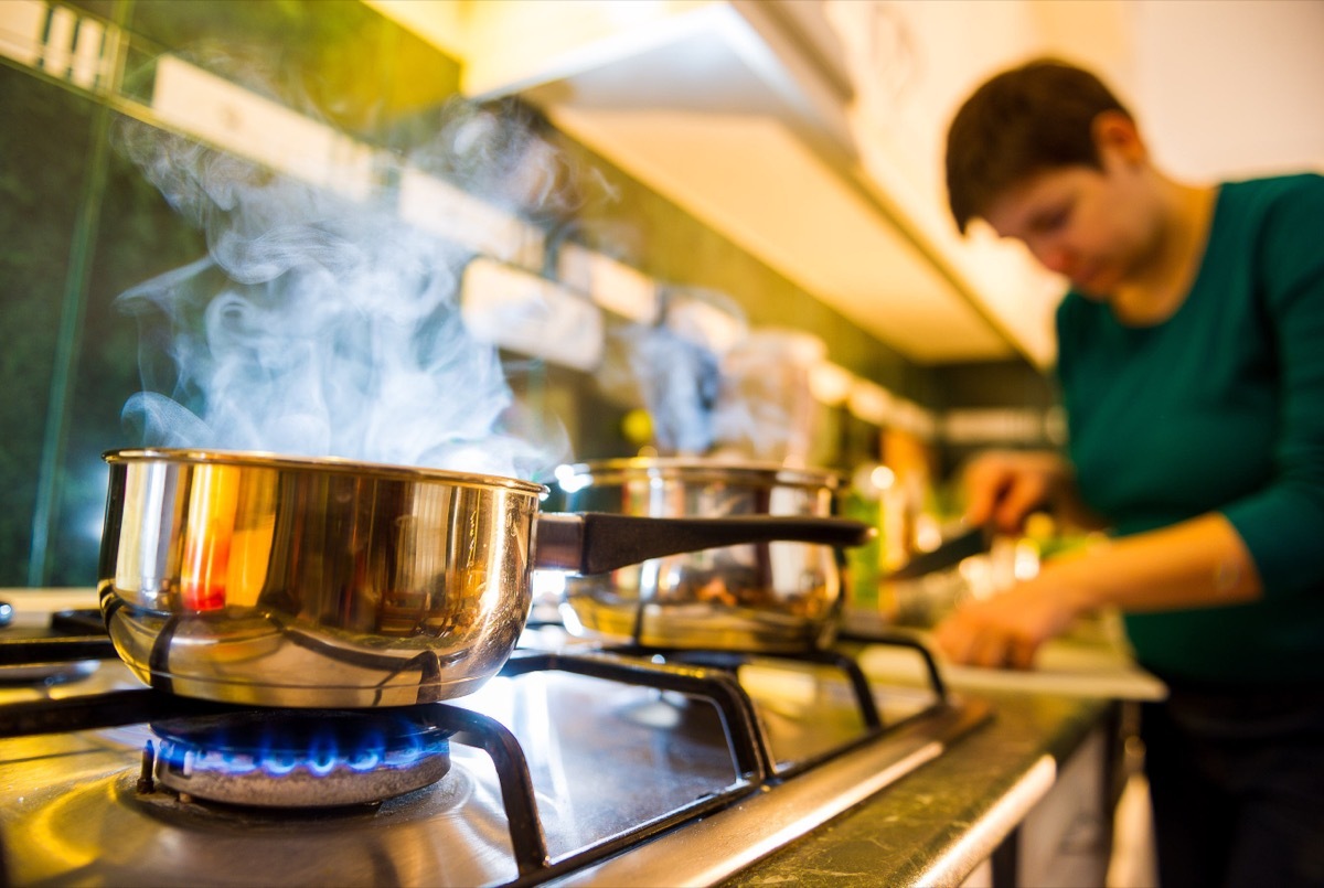 woman cooking food on gas stove