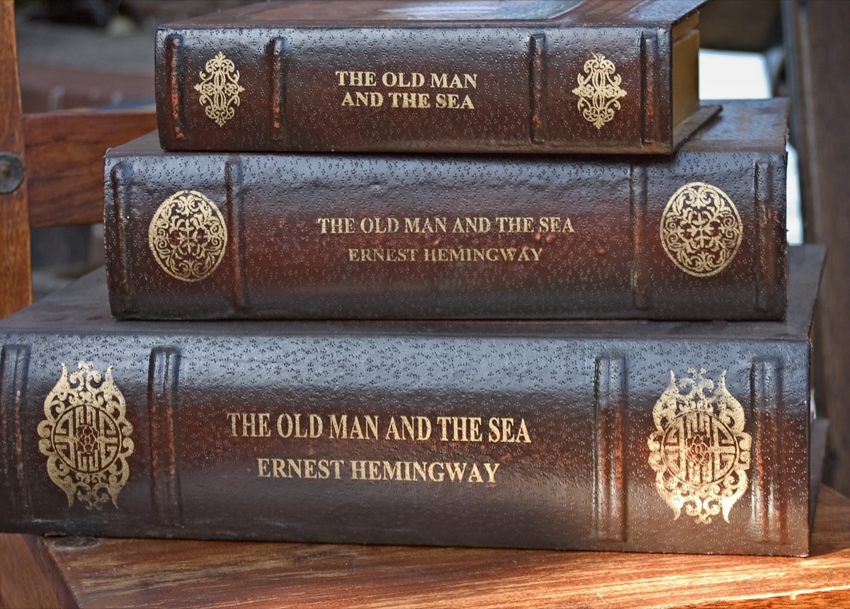 Three stacked leather bound books by Ernest Hemingway. - Image