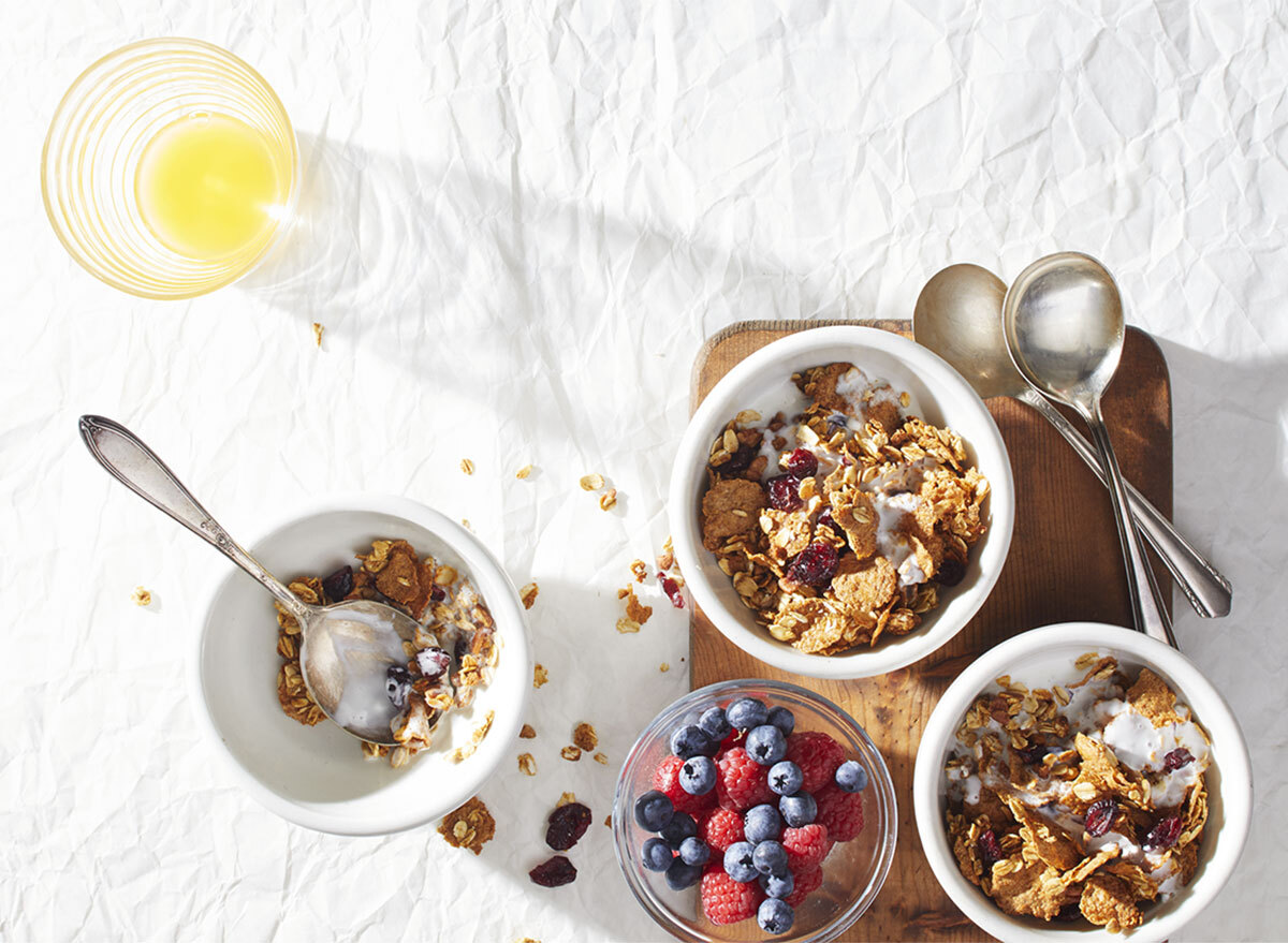 cranberry orange granola bowls with bowl of berries and spoons