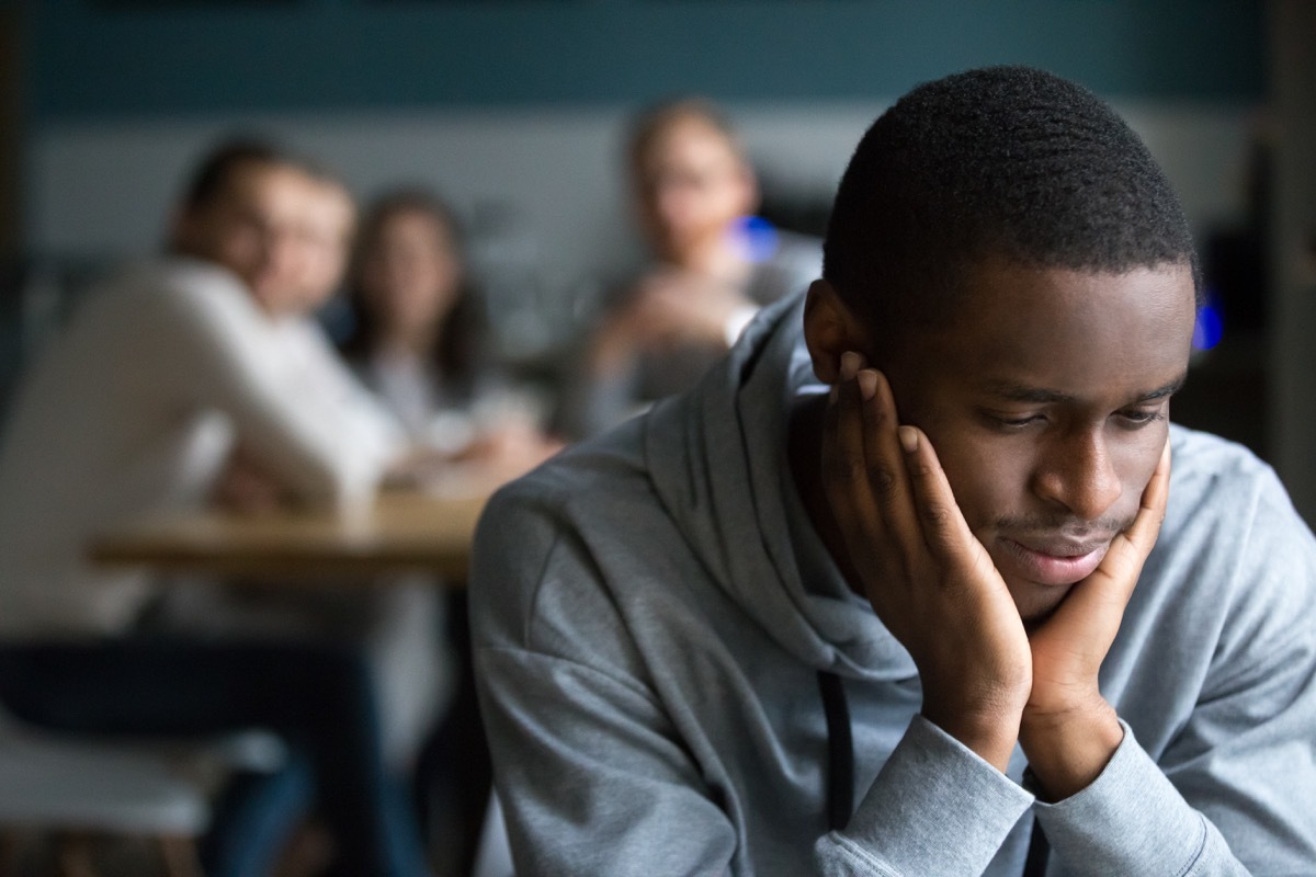 Antisocial black man avoiding conversation with his peers