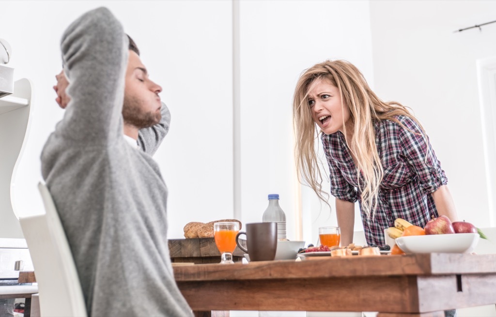 Woman yelling at her boyfriend in the kitchen, signs of cheating