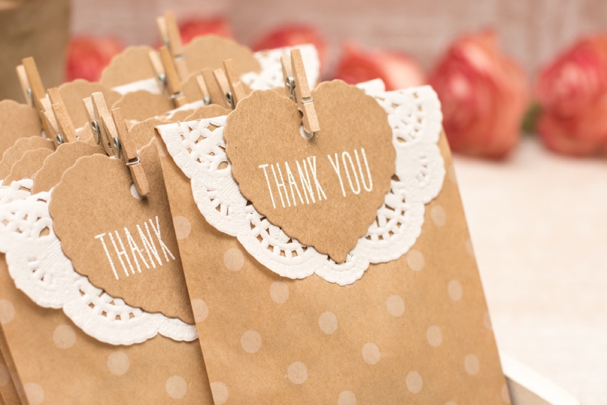 brown paper gift bags with white doily and thank you note clothes-pinned to it