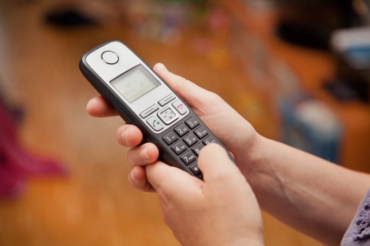 woman holding cordless phone