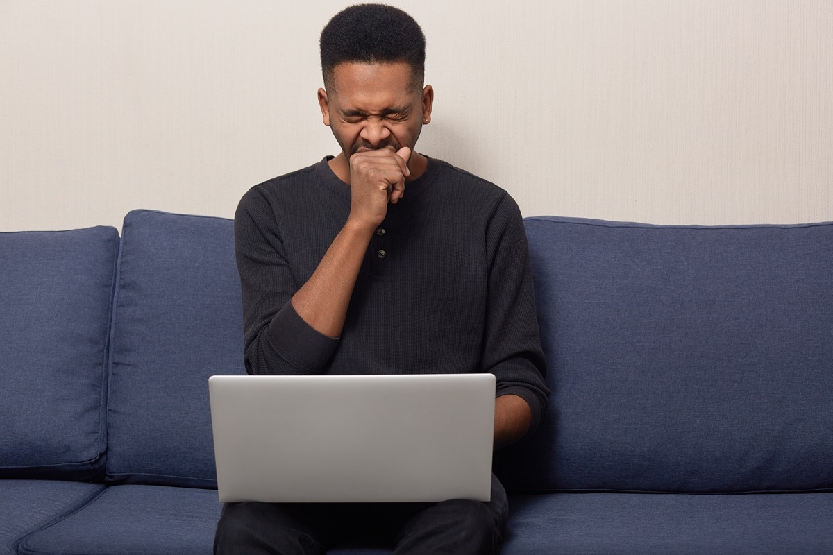 Man Yawning While He Scrolls on His Laptop, contagious conditions