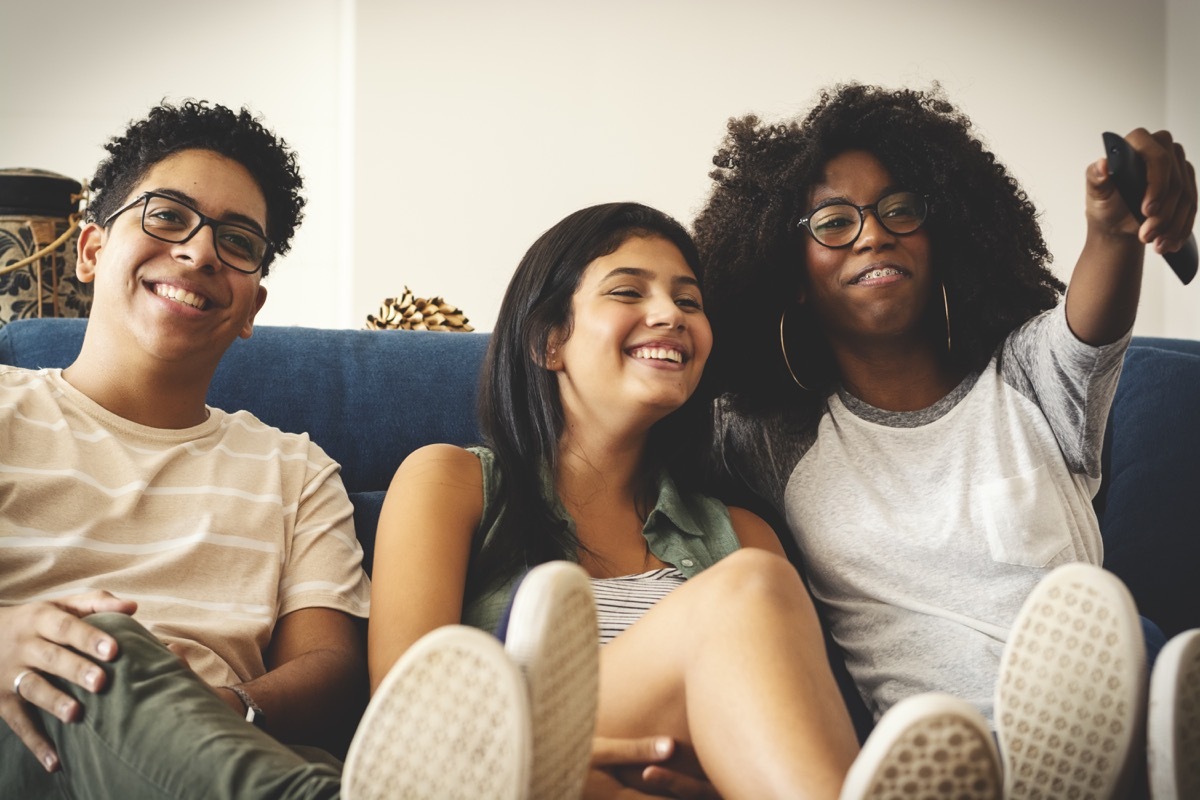 three teenagers watching tv together