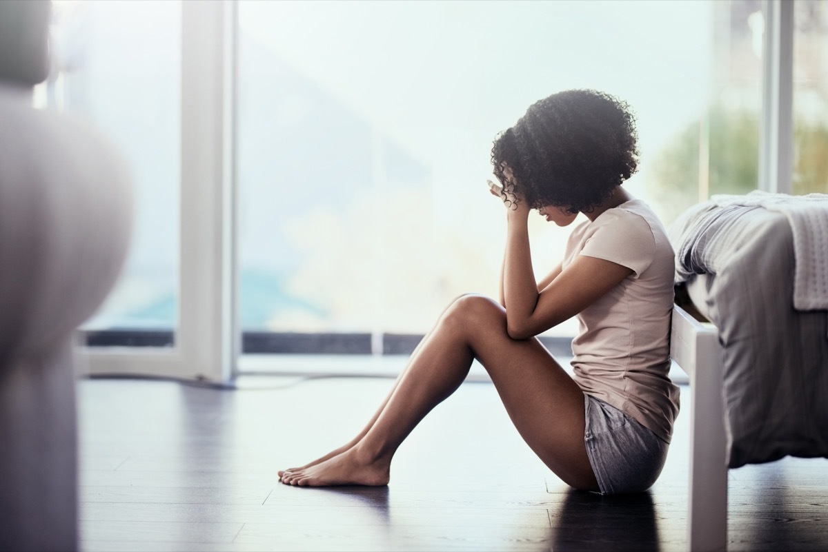 Shot of a young woman suffering from depression in her bedroom