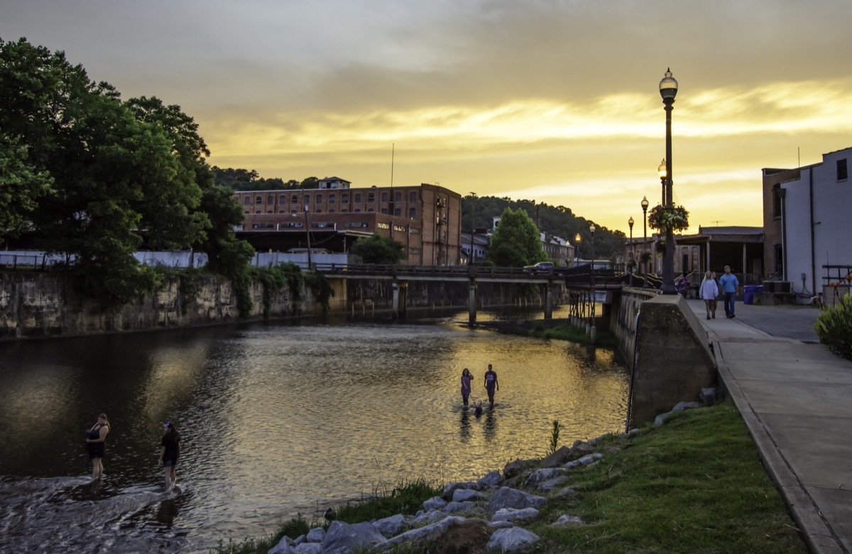 Prattville, Alabama/USA-June 12, 2019: A scenic view of people enjoying Autauga Creek and the Creekwalk area of Prattville during a beautiful golden sunset on a warm summer evening.