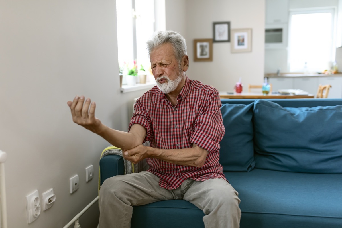 Man suffering from pain and rheumatism.Pain in the elbow The man is holding his elbow, he feels strong pain.