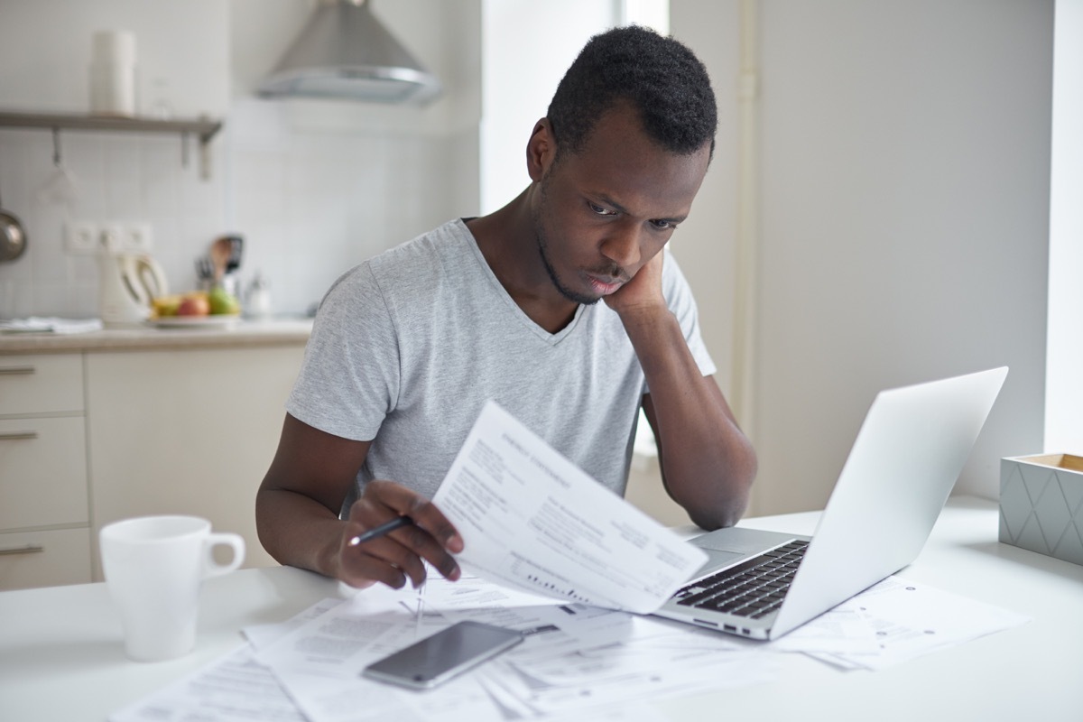 man looking at his utility bill, spam letters