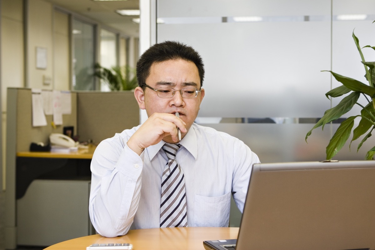 man chewing on a pen