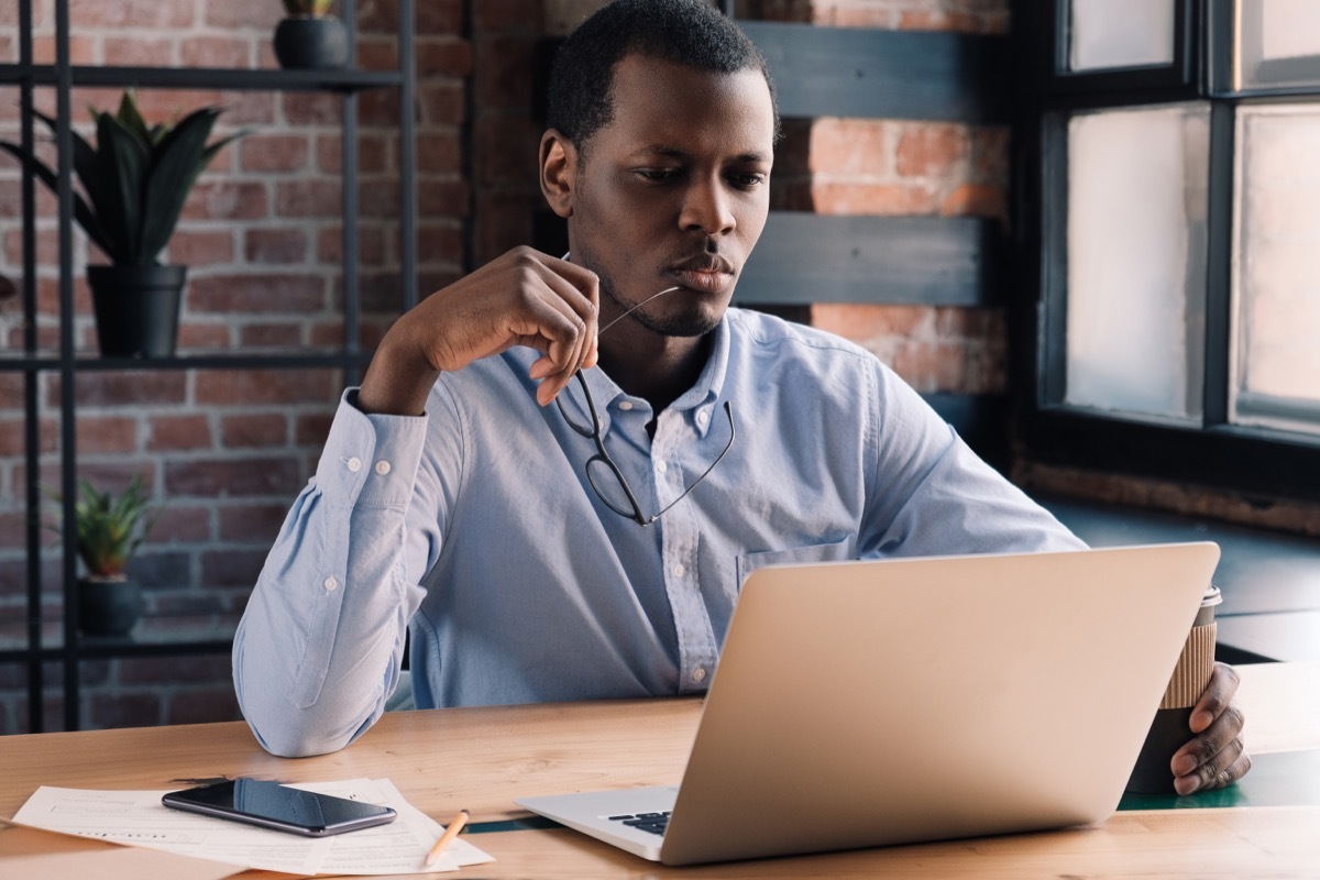 Young Black Man Thinking at Laptop