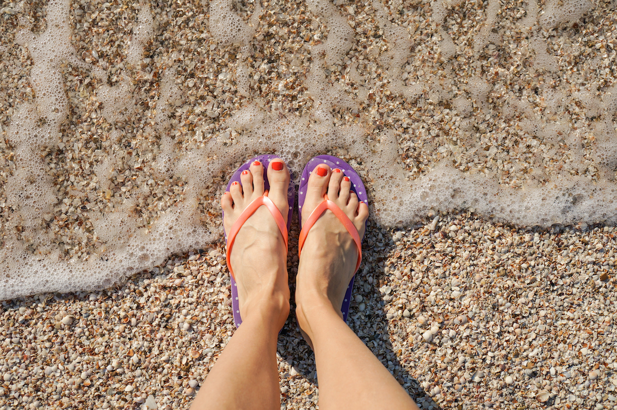 Female,Legs,Wearing,Flip,Flops,Near,Sea.,Top,View