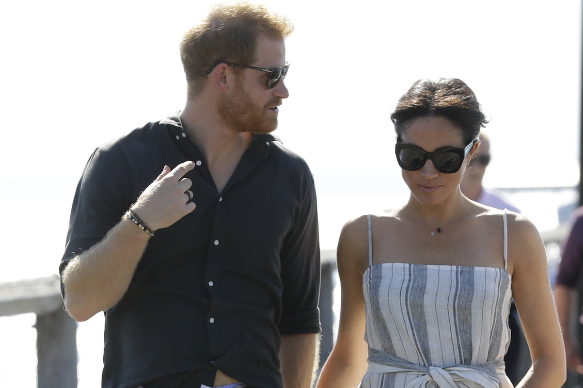 Britain's Prince Harry and Meghan, Duchess of Sussex walk along Kingfisher Bay Jetty during a visit to Fraser Island, Australia, Monday, Oct. 22, 2018