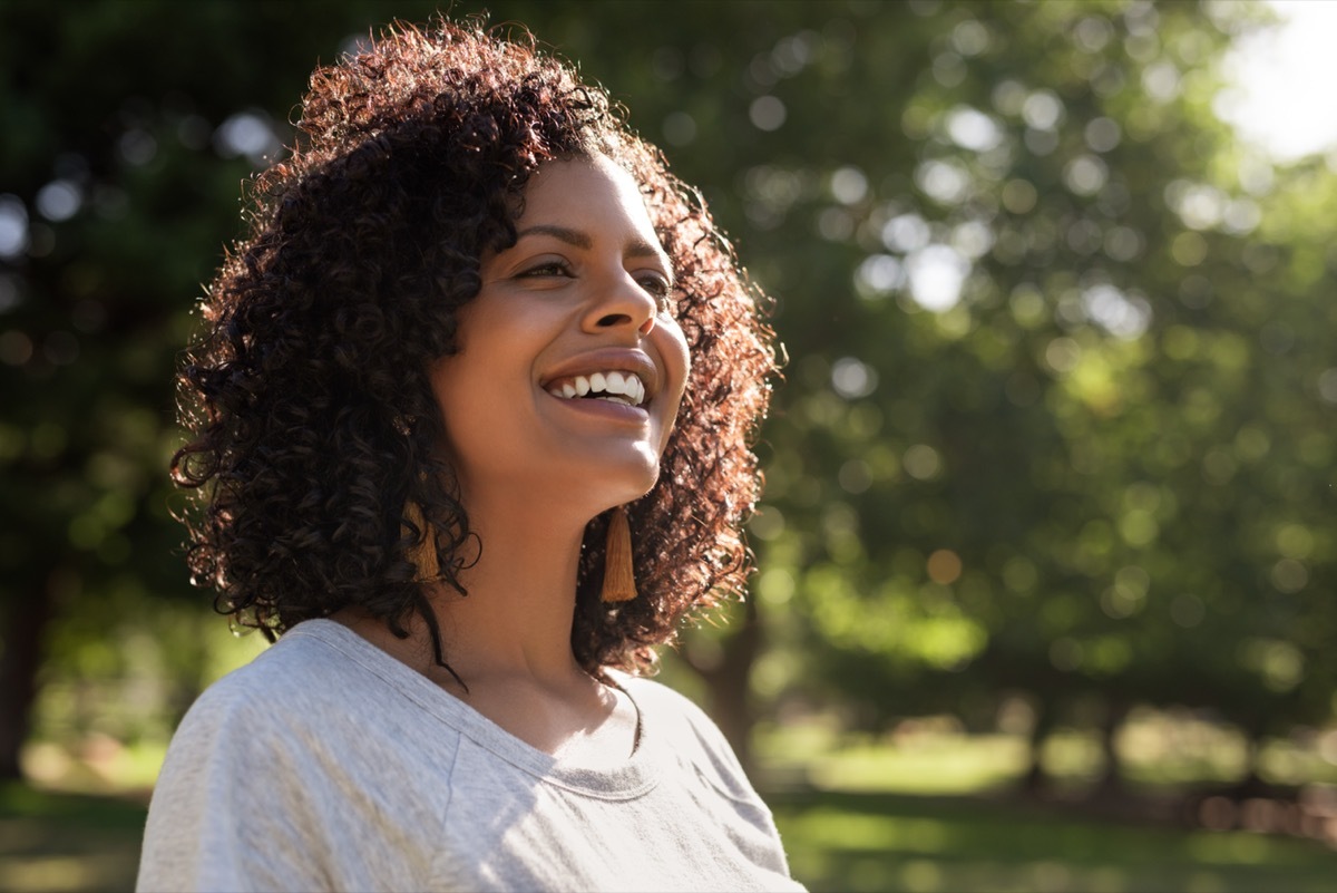 Happy woman smiling outside in nature.