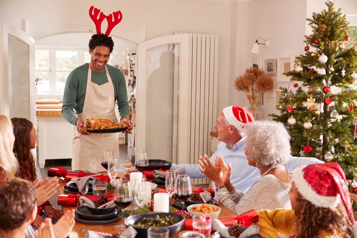 dad coming out with a turkey to place on the christmas dinner table